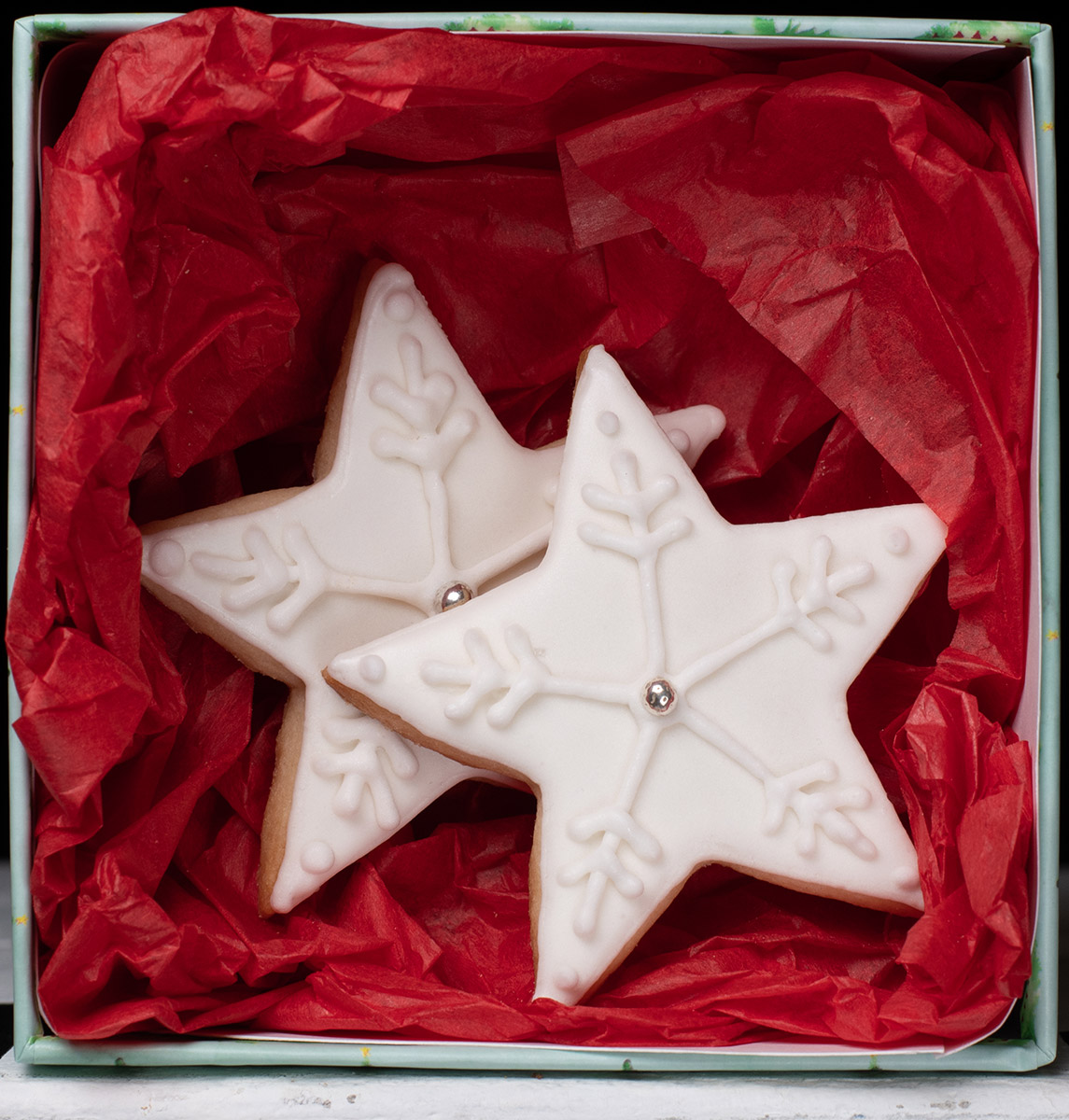 Star-shaped sugar cookies in a box with red tissue paper