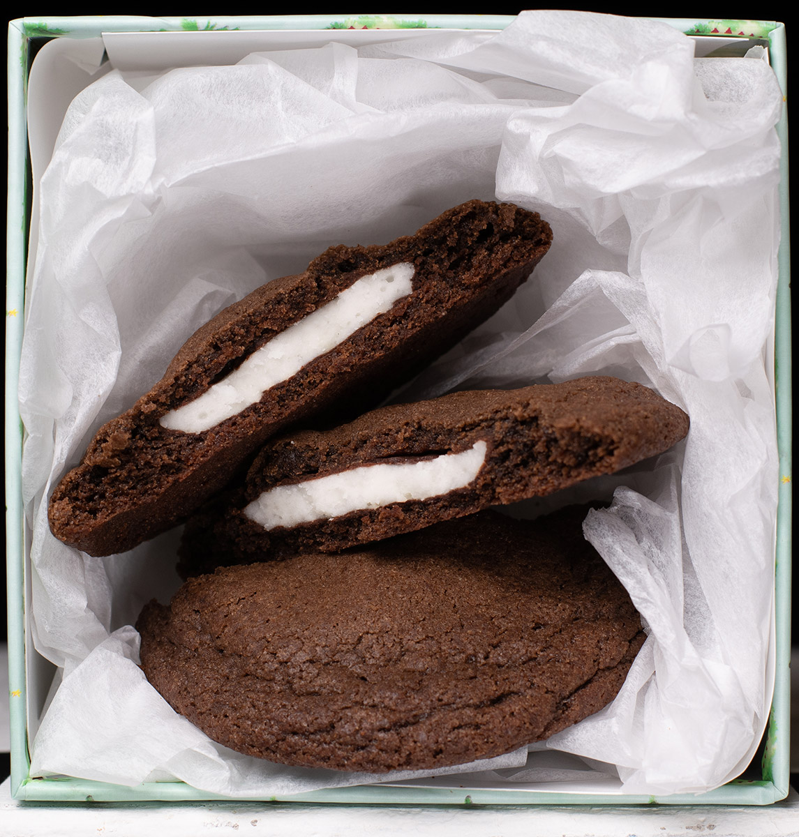 Dark chocolate mint cookies in a box with white tissue paper